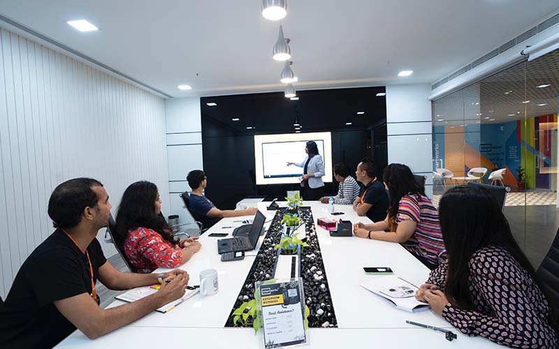 People sitting at a conference table watching a presenter