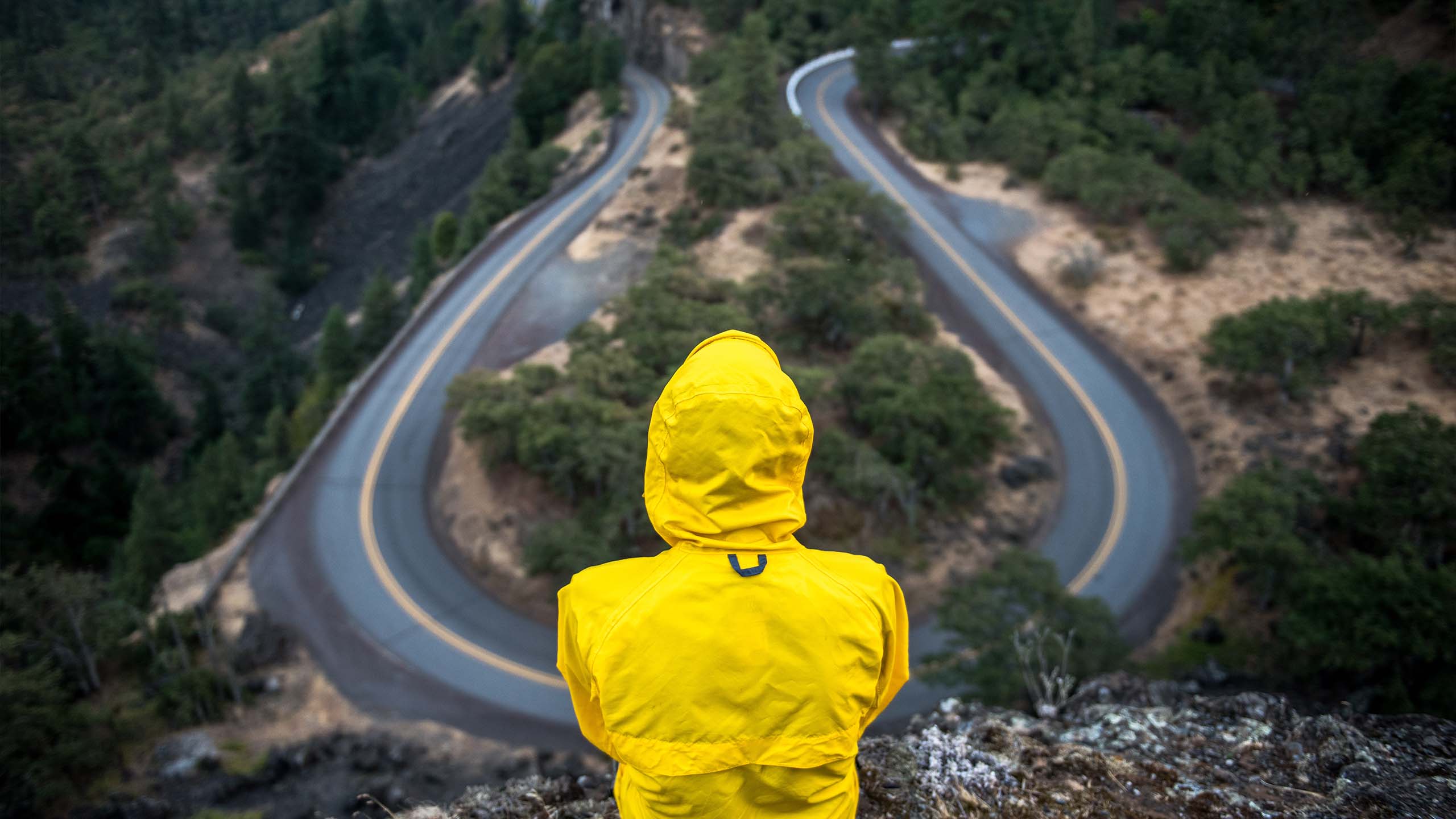 Person sitting looking down at a curvy road