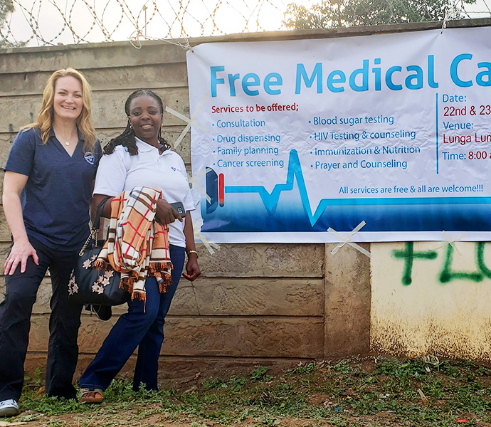 Lori Most in front of free medical camp sign